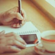 person writing in a copy book