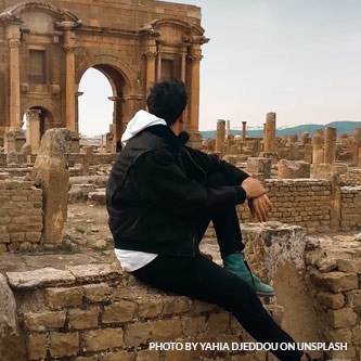 Guy sitting in an ancient ruins site