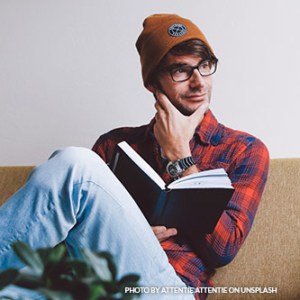 Guy with casual clothes reading a book