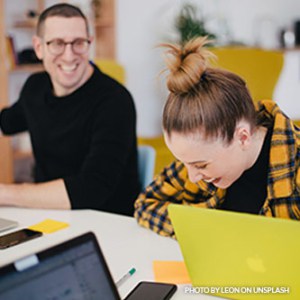 man and woman laughing in office